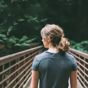 Nainen kävelemässä sillalla.