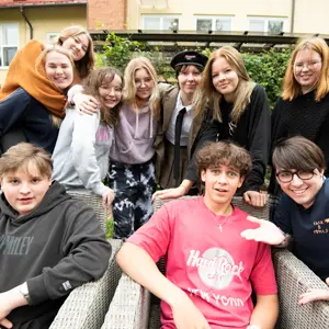 Hymyileviä lukiolaisia rykelmässä lähekkäin.