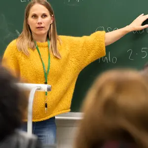 Kouluttaja osoittaa taululla näkyvää tehtävää.